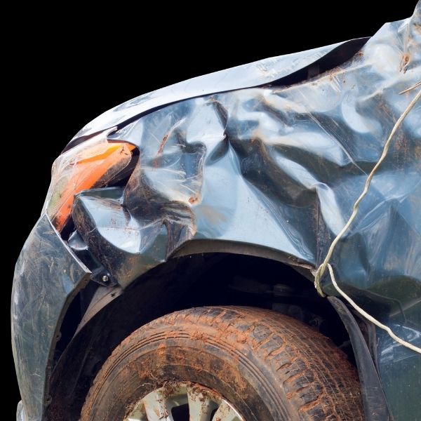 Front left wheel of a blue car that has been crunched in.