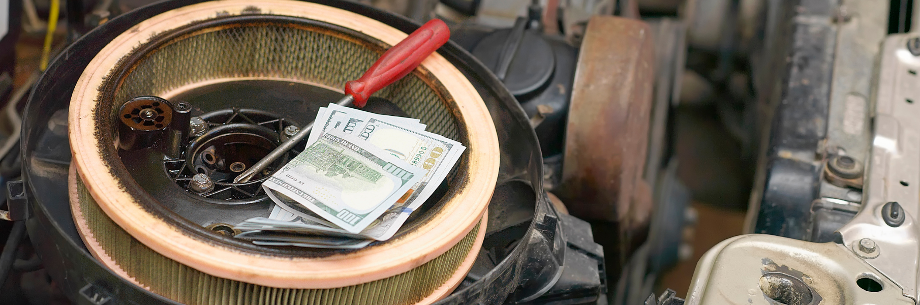 cash lying inside hood of a vehicle with tools