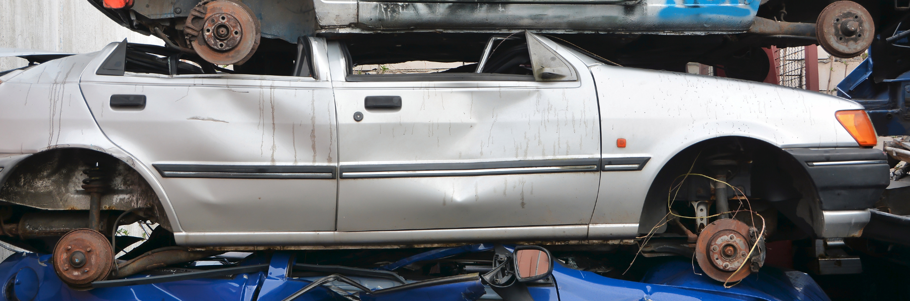 junk car sitting in junkyard surrounded by other vehicles