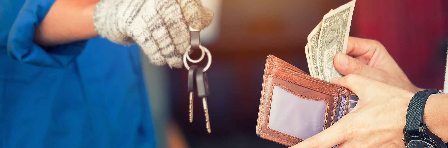 Two people's hands are show exchanging cash for car keys